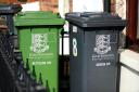 A green recycling wheelie and bin and a black rubbish bin outside a home in Great Yarmouth.
