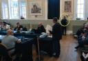 A security guard watches over a meeting of Thetford Town Council