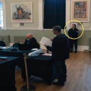 A security guard watches over a meeting of Thetford Town Council