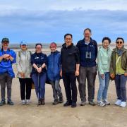 Visitors from the Republic of Korea, with RSPB staff on the beach at Titchwell