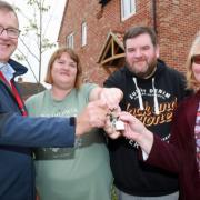 Claire and Robert Shearing (centre) receive the keys to their new home from Michael Newey, chief executive of Broadland Housing (left), and Cllr Wendy Fredericks, deputy leader of North Norfolk District Council.