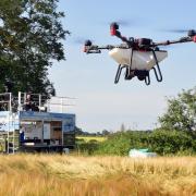 Andy Sproson from Auto Spray Systems controls the firm's aerial drone from a platform as it spreads cover crop seeds at Eves Hill Farm