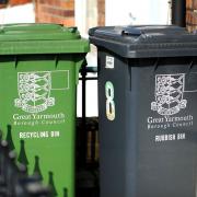A green recycling wheelie and bin and a black rubbish bin outside a home in Great Yarmouth.