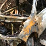 A burnt out vehicle was found in a woodland area