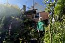 Gill Hayes-Newington pictured in front of her neighbours scaffold in her garden