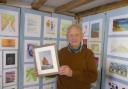 Peter Wade-Martins, chair of Dereham Heritage Trust, Holding a replica of a John Craske picture.