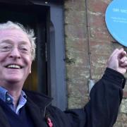 Sir Michael Caine in 2003 with his blue plaque in North Runcton