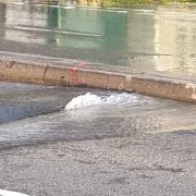 A burst water main has flooded a main town centre road