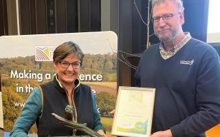 Louise Bond, who manages Bedingham Hall Farm near Bungay, is presented with the Ian MacNicol Trophy by Rob Holland, from sponsor Anglian Water